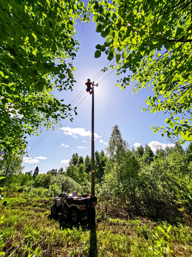 Verkostoasentaja sähköpylvään päässä